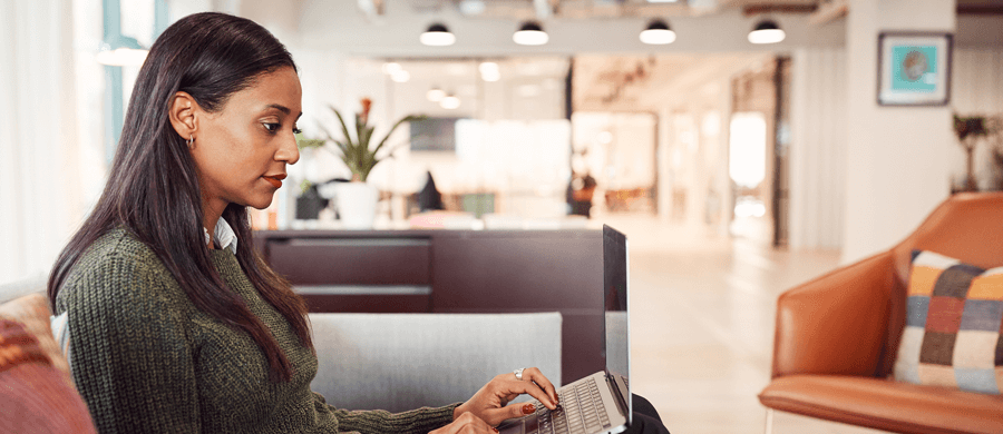 Professional woman typing on a laptop in an office