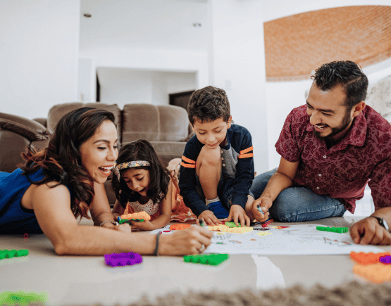 Young family of 4 playing with toys in the living room
