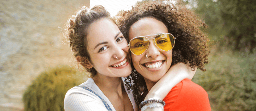 Two young smiling women hugging