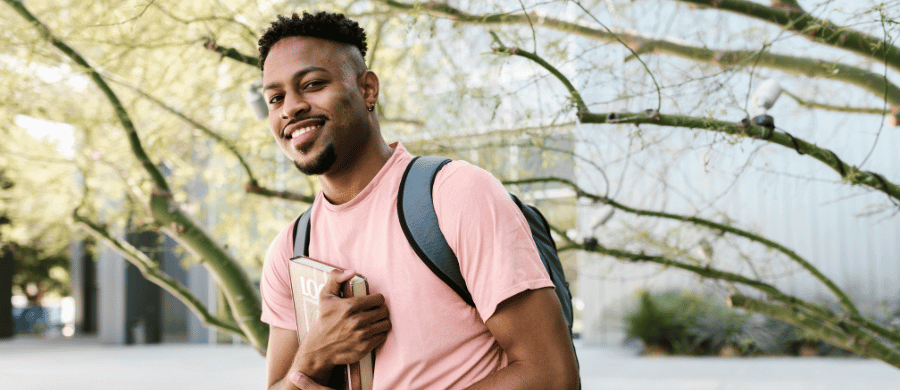 Male college student holding textbook