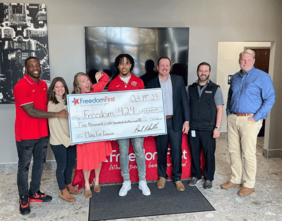Liberty University football players presenting donation check to Freedom 424