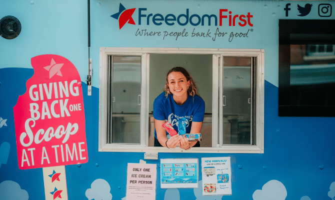 Freedom First employee posing in the window of Scoop