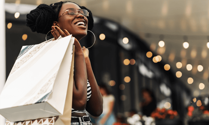 Smiling young woman in a mall holding shopping bags