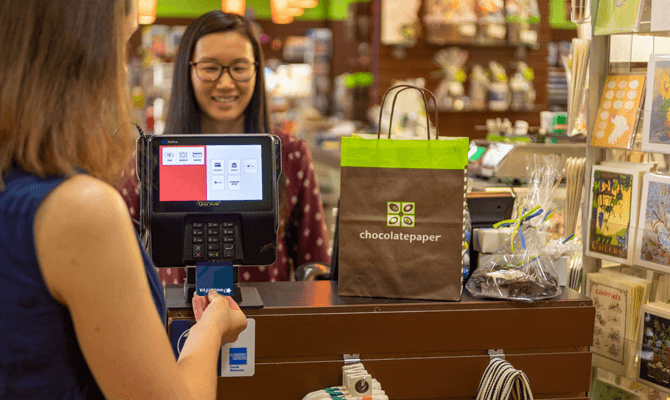 Woman using a Freedom First debit card to pay at Chocolate Paper