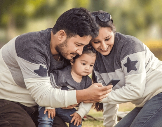 Young family of 3 looking at a smartphone together