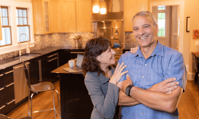 Older couple smiling at each other in an open kitchen