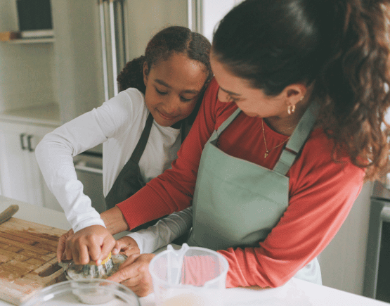 Mother and daughter squeezing lemon while baking together