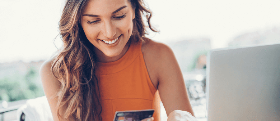 Smiling young woman looking down at smartphone