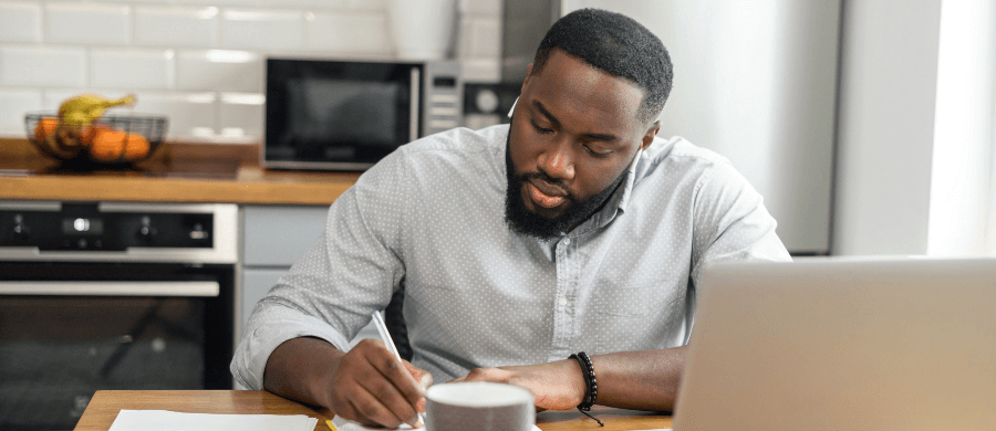 Serious man reviewing documents in his kitchen