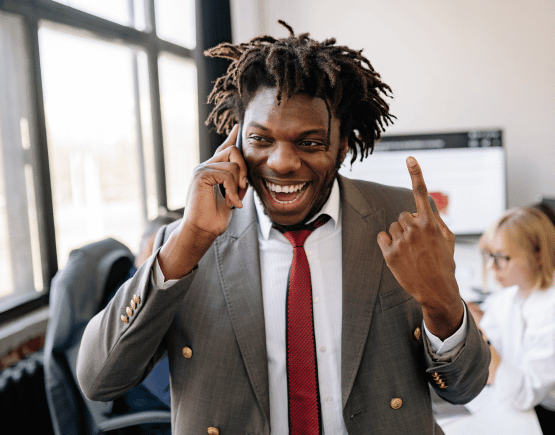 Young professional man talking on phone in office excitedly