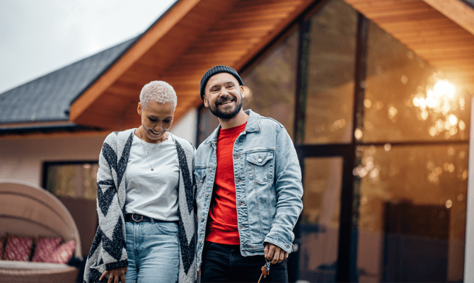 Affectionate couple standing in front of their home