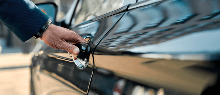 Man's hand opening black car door