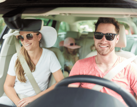 Family of 4 riding in a car wearing sunglasses