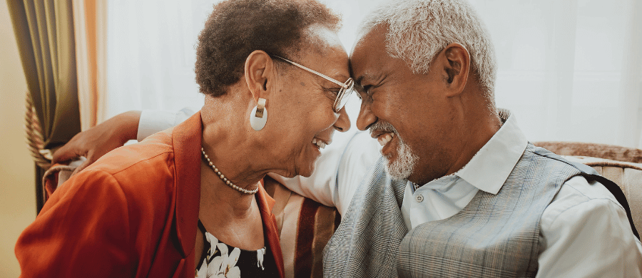Loving elderly couple touching foreheads and smiling
