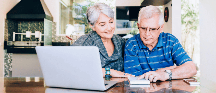 Older couple reviewing finances in front of a laptop