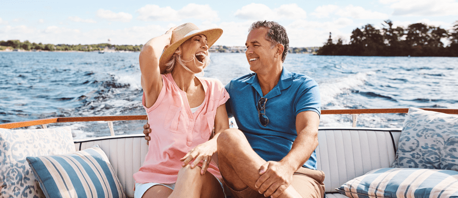 Older couple laughing on a leisure boat in a lake