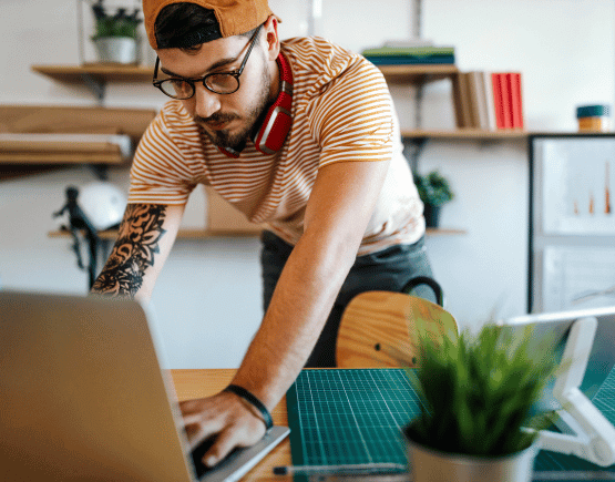 Young tattooed man using laptop