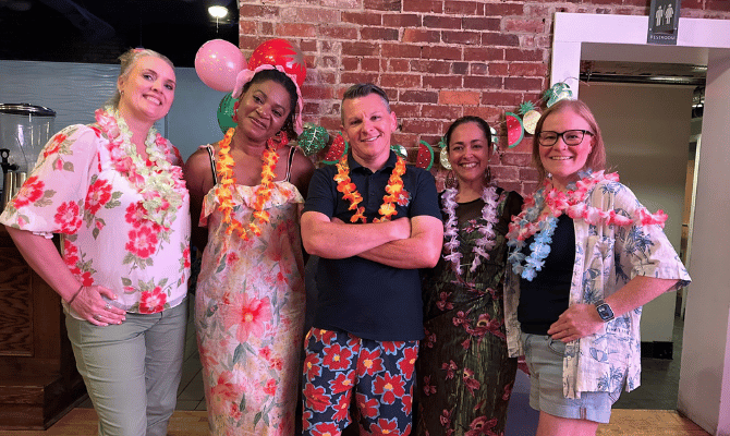 Freedom First employees in tropical vacation garb at a company social