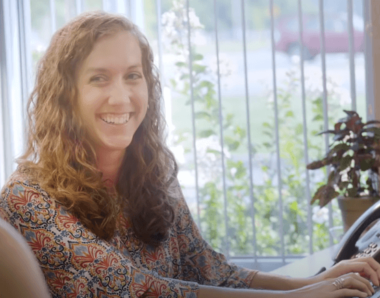 Smiling woman at Freedom First branch typing