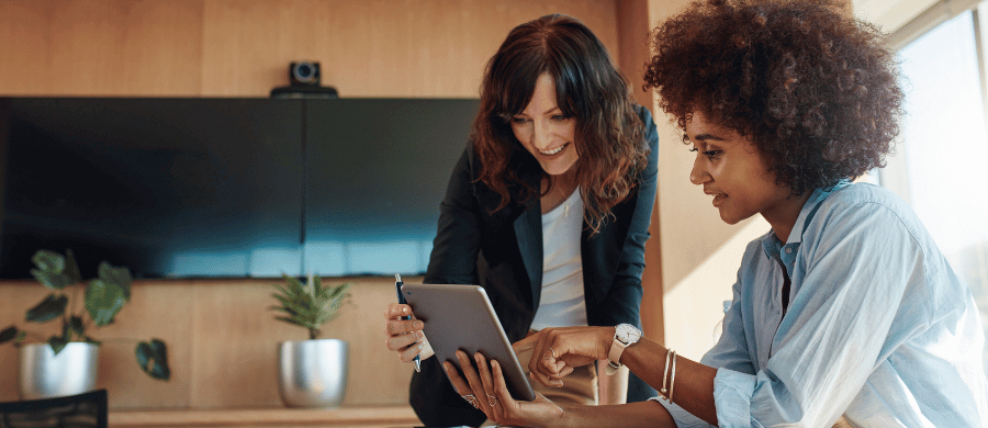 Two professional women looking at a tablet