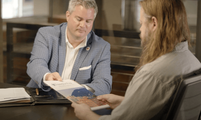 Jeremiah Clarke showing Private Banking materials to a client