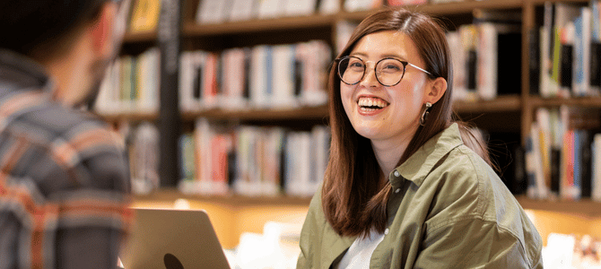 Smiling student studying in school library