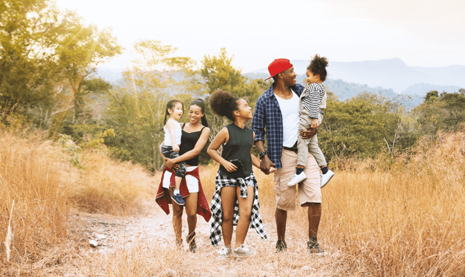 Young family of 5 hiking together in the summer