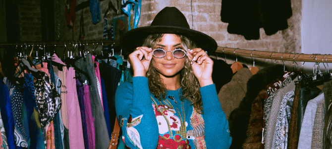 Young woman trying on sunglasses at a vintage shop