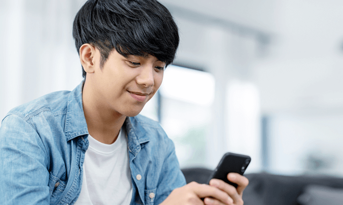 Young man smiling at his smartphone