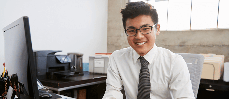 Young man in glasses at office desk