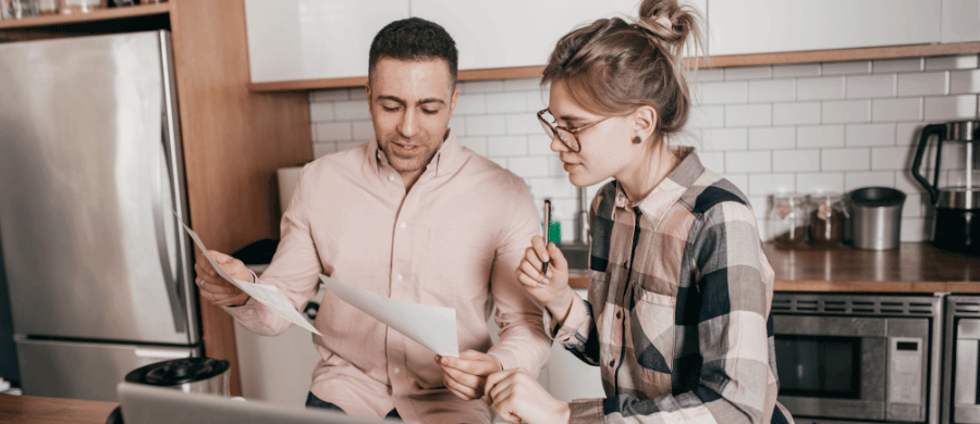 Young couple looking over documents in kitchen