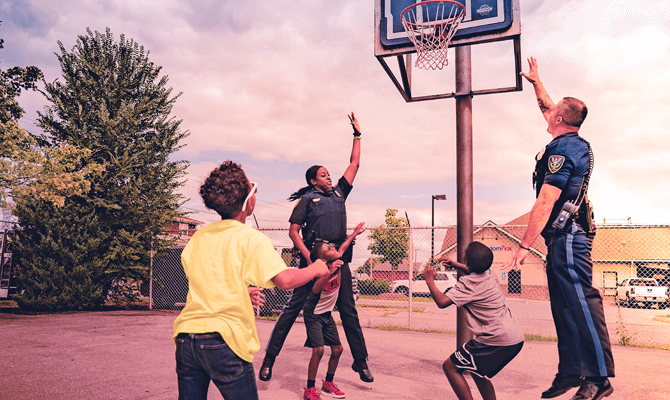 Two Roanoke City police officers playing basketball