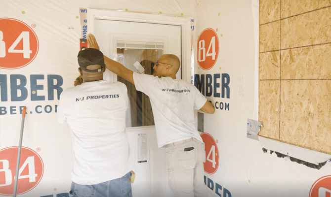 KJ Ford and his teammate measuring a door frame at a construction site