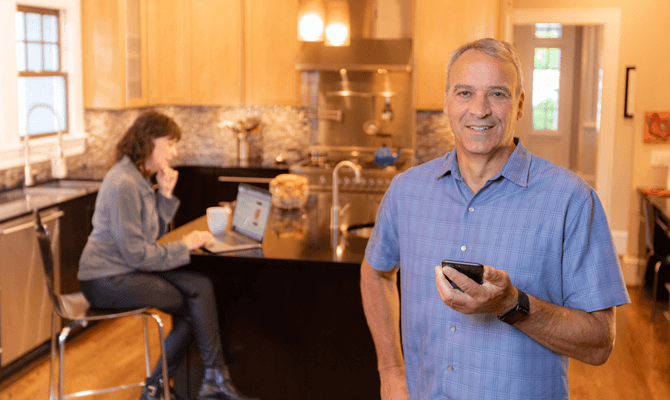 man holding phone in kitchen