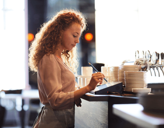 Woman using POS system in a restaurant