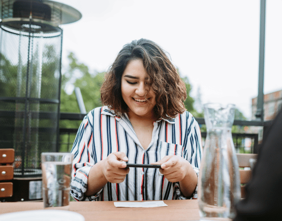 Young woman taking picture of check on her phone